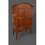 A Regency mahogany cabinet on stand, the arched cornice above two doors, the lower section with a