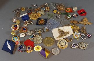 A collection of military badges and buttons, together with other similar badges