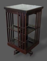 An Edwardian mahogany revolving bookcase with an arrangement of shelves, 98cms tall