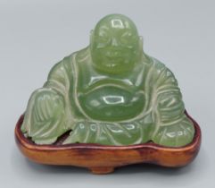 A Chinese carved jade Buddha upon hardwood stand, 5.5cms tall