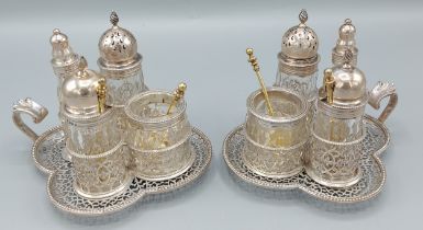 A pair of Victorian silver Cruet stands of pierced form, each with four glass and silver mounted