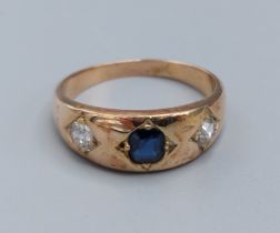 A yellow metal Diamond and Sapphire ring set with a central sapphire flanked by diamonds, 5.6gms,