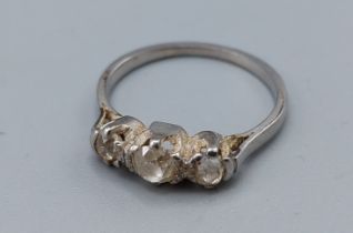 A white metal three stone diamond ring, claw set, ring size M, 3.2gms