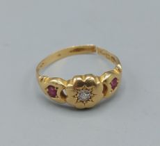 An 18ct gold ring set with central diamond flanked by rubies, ring size O, 2.9gms
