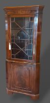 A mahogany standing corner cabinet, with moulded cornice and astragal glazed door above a panel