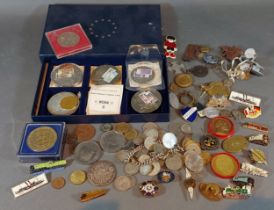 A collection of commemorative coins, together with a collection of railway related badges and others