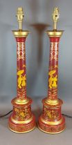 A pair of Toleware table lamps, each with gilded decoration upon a red ground, 60cms tall