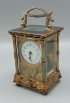 An Art Nouveau brass and ormolu cased carriage clock decorated with stylised flowers the circular
