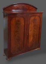 A 19th Century mahogany hall cupboard, the arched back above a moulded top and two panel doors