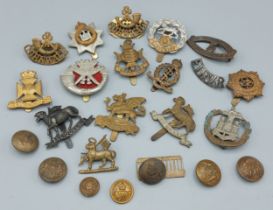 A collection of WWI cap badges, buttons and shoulder titles