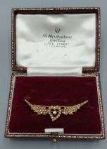 A gold brooch with a central heart flanked by wings, Pearl set, 4.7cms long, 3.5gms