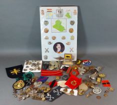 A small collection of military cap badges, together with other related items