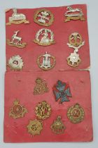 A collection of sixteen WWI cap badges