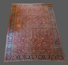 A Heriz carpet with all over design within multiple borders upon a red and blue ground, 293cms by