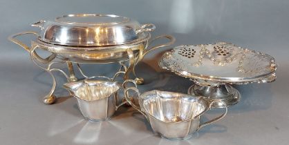 A silver plated entree dish on stand together with a plated fruit basket, sucrier and cream jug