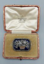 An Edwardian gold brooch in the form of a basket of flowers set with Diamonds on an enamel panel and