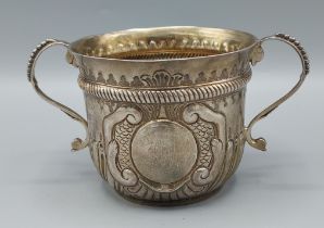 A Victorian silver porringer with embossed decoration and twin shaped handles, London 1896, 5ozs