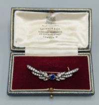 An Edwardian gold brooch in the form of wings with a central oval Sapphire flanked by Diamonds,
