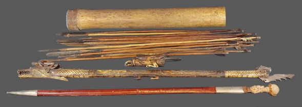 An Indonesian bone blowpipe together with a collection of arrows and a sword