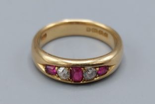 An 18ct gold Ruby and Diamond ring set with three Rubies and two Diamonds, 6.3gms, ring size M