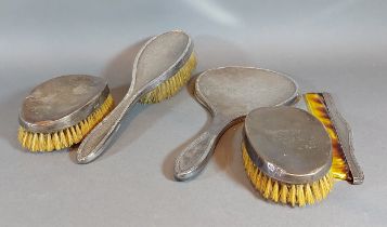 A Birmingham silver hand mirror together with three silver backed brushes and a silver mounted comb