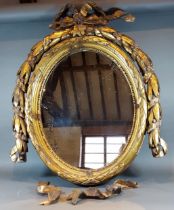 A 19th Century French gilded wall mirror of oval form with bow cresting, 77cms x 64cms together with