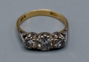 An 18ct gold three stone Diamond ring, the three graduated Diamonds claw set, 3.2gms, ring size O