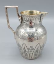 A Victorian silver cream jug, with engraved decoration and shaped handle, London 1879, 5ozs