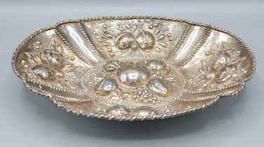 A Continental white metal oval dish, embossed decoration with fruit, 21cms by 29cms, 14ozs