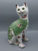 A Galle style pottery model in the form of a cat with glass eyes, 34cms tall