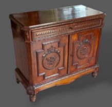 A 19th Century French Commode, the carved moulded top above two carved panel doors flanked by reeded