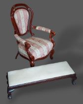 A Victorian style armchair together with a long stool