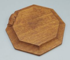 A Robert Mouseman Thompson, carved oak cheese board of octagonal form, decorated with a carved