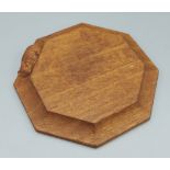 A Robert Mouseman Thompson, carved oak cheese board of octagonal form, decorated with a carved