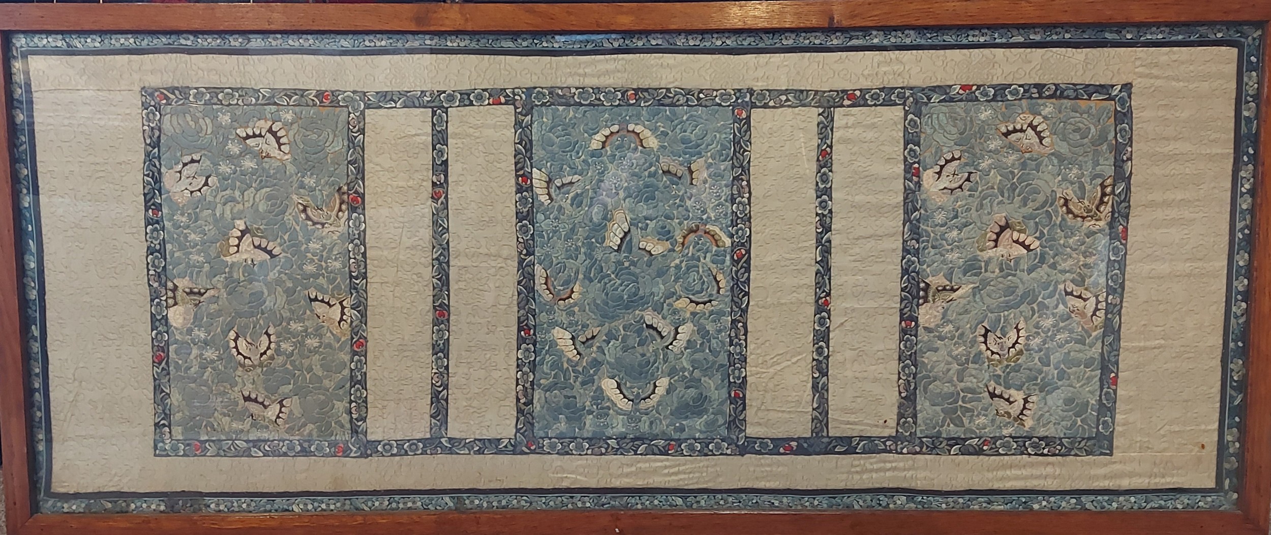 A Chinese silkwork panel decorated with butterflies amongst foliage, 44cms x 113cms