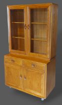 An Ercol Windsor side cabinet with two glazed doors enclosing shelves, the lower section with two