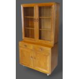 An Ercol Windsor side cabinet with two glazed doors enclosing shelves, the lower section with two