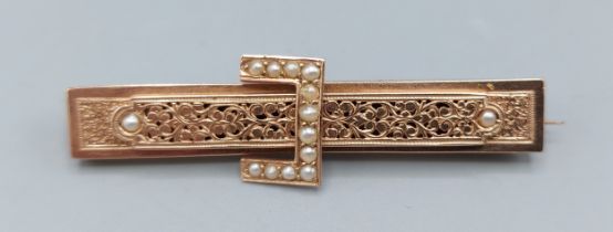 A 560 marked gold brooch in the form of a buckle, set with pearls and with engraved decoration, 4gms