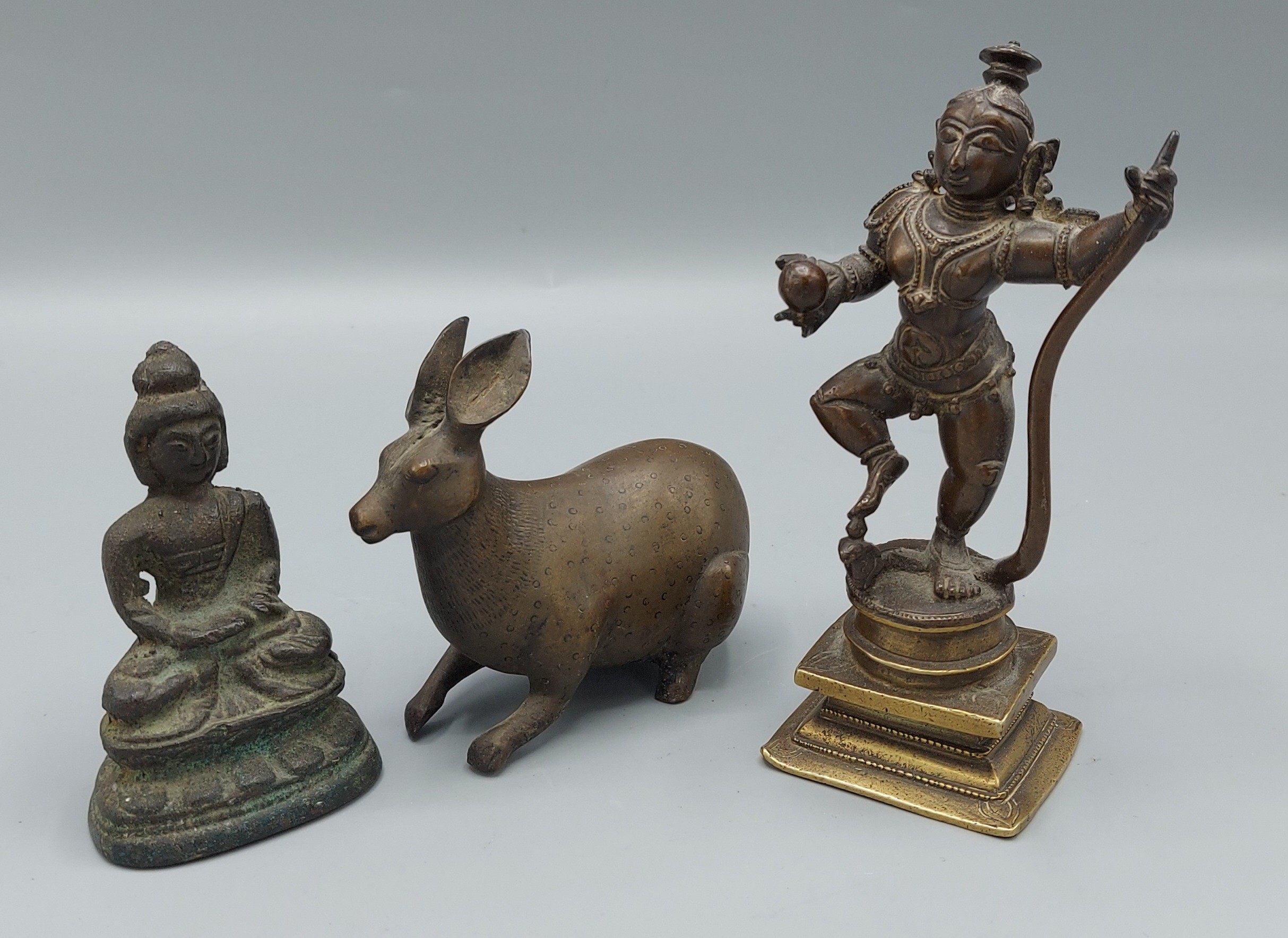 An Indian bronze figure with snake, 13cms tall, together with a bronze Buddha and a Bronze model