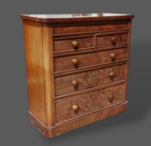 A Victorian mahogany chest with a concealed frieze drawer above two short and three long drawers