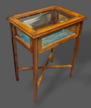 An inlaid bijouterie cabinet, the hinged top above square legs with crossover stretcher, 58cms wide,