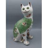 A Galle style pottery model in the form of a cat with glass eyes, 34cms tall