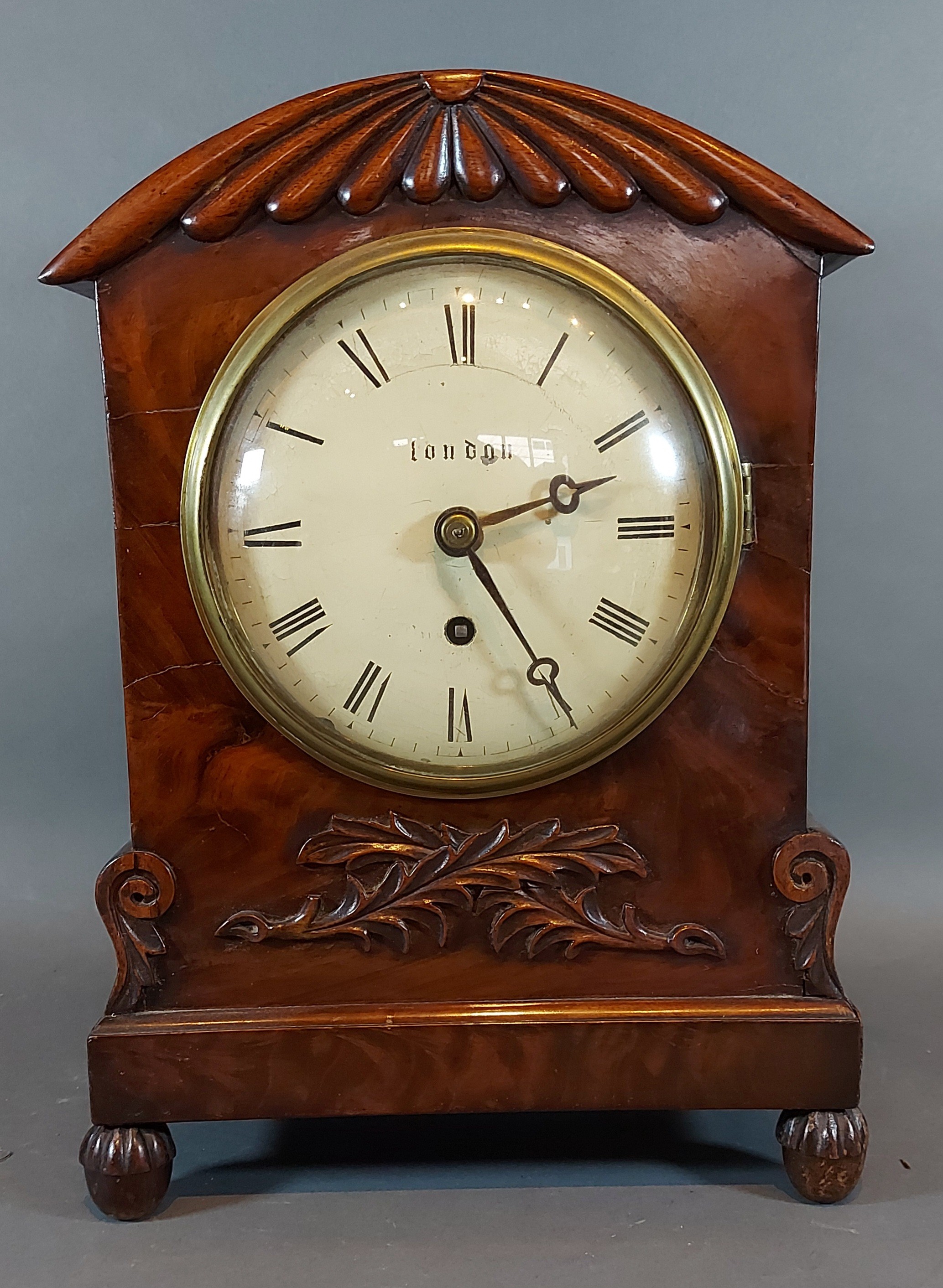 A William IV mahogany cased bracket clock with carved and shaped case,the circular enamel dial