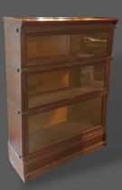 A Globe Wernicke style Oak three section bookcase with glazed doors upon a shaped base, by AMYL,