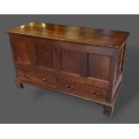 A George III oak mule chest, the hinged top above two drawers raised upon bracket feet, 136cms wide,