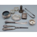 A silver salt together with a pair of Georgian silver sugar tongs and other items to include two