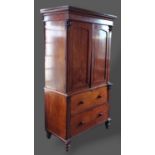 A William IV mahogany press cupboard, the moulded cornice above two panel doors enclosing shelves,