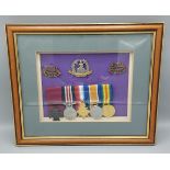 A group of three Royal Norfolk cap badges together with a replica medal group of five 1st World