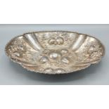 A Continental white metal oval dish, embossed decoration with fruit, 21cms by 29cms, 14ozs