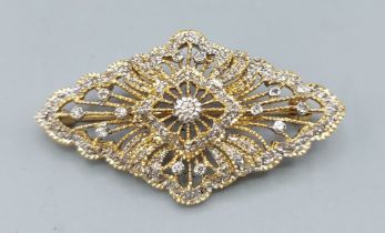 An 18ct gold brooch of pierced shaped form set with Diamonds, 8gms